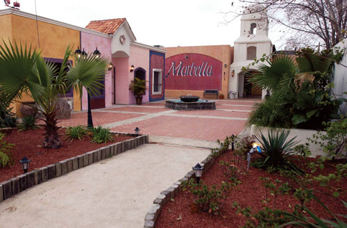 Julio del Carpio in the East End. Below, the renovated Marbella building houses a bar that looks like a bullfight arena.